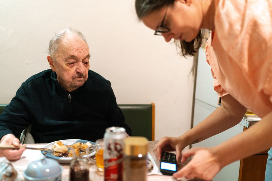 Cuidadora ayudando a comer a una persona mayor con disfagia