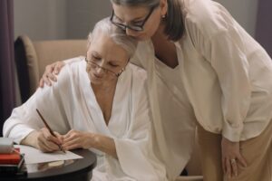 Cuidadora familiar revisando papeleo de la dependencia con su madre mayor en casa