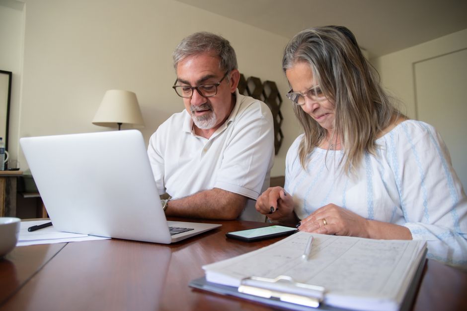 Persona mayor y cuidadora revisando documentos de dependencia