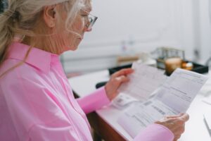 Persona mayor revisando documentos en casa para tramitar el certificado de discapacidad