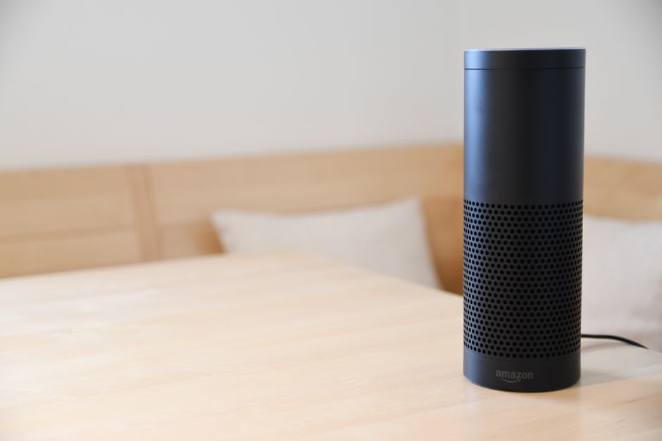 Persona mayor usando un altavoz inteligente con asistente de voz en casa