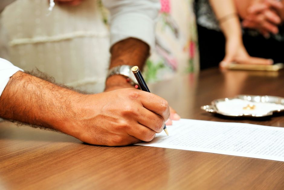 Documento legal firmado sobre una mesa junto a unas gafas y una taza de café