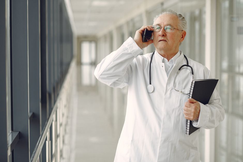 Médico conversando con un hombre mayor en la consulta