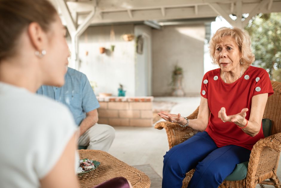 Una mujer mayor conversa con su hija en casa sobre las ayudas de la Ley de Dependencia